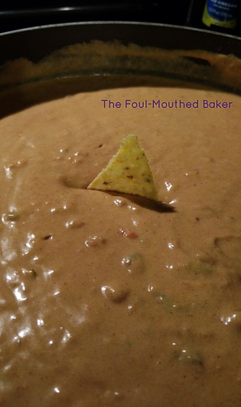 A lonely tortilla chip in a sea of delicious vegan cheese dip.